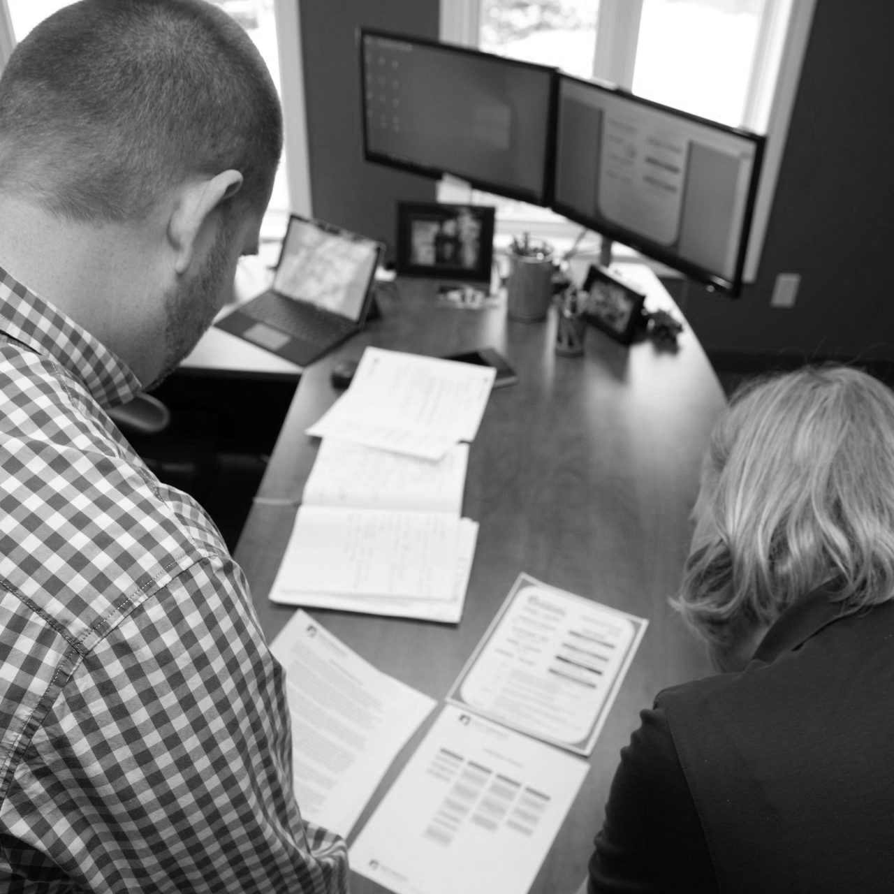 man and woman looking at paper work on a desk